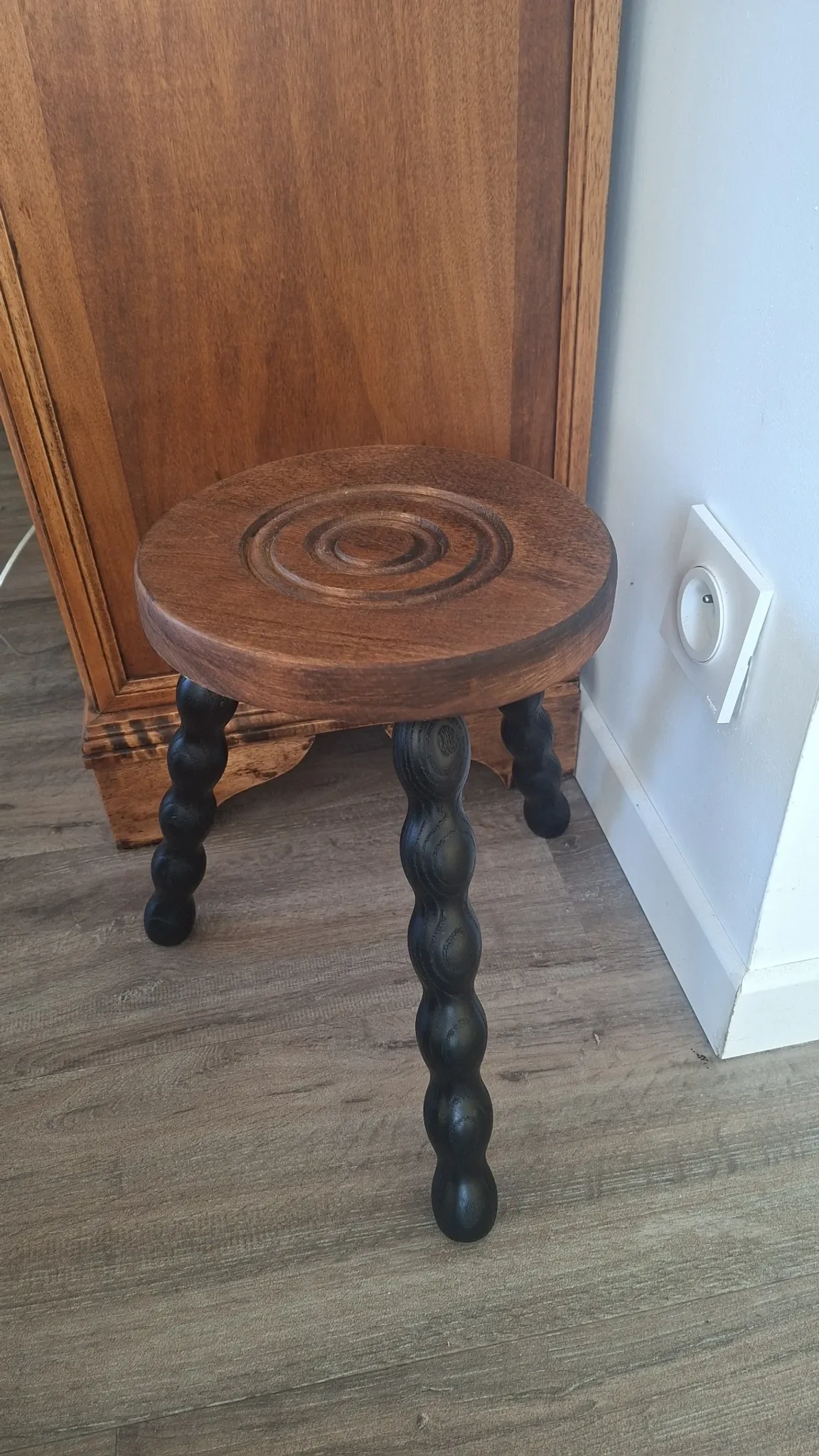 Brown and black wooden tripod stool