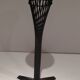 Brass ashtray on a stand made of black lacquered metal wire.