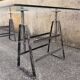 Large vintage industrial glass table with adjustable metal trestles.