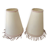 2 off-white fabric lampshades with pink and white tassels