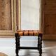Antique turned wooden stool with woven leather.