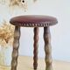 Antique tripod stool with turned wooden legs and leather seat.