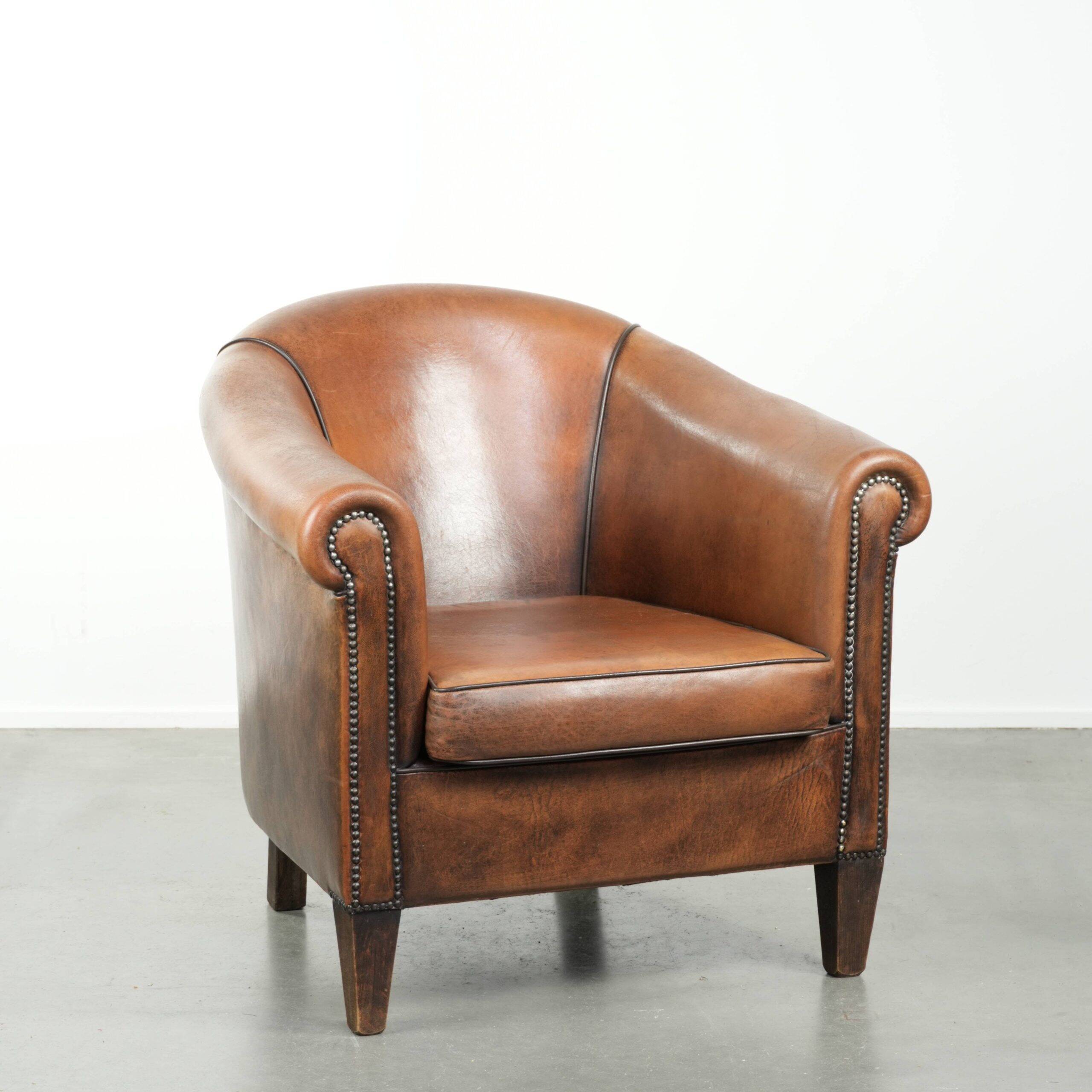 Sheepskin club armchair with beautiful patina and finish with black piping