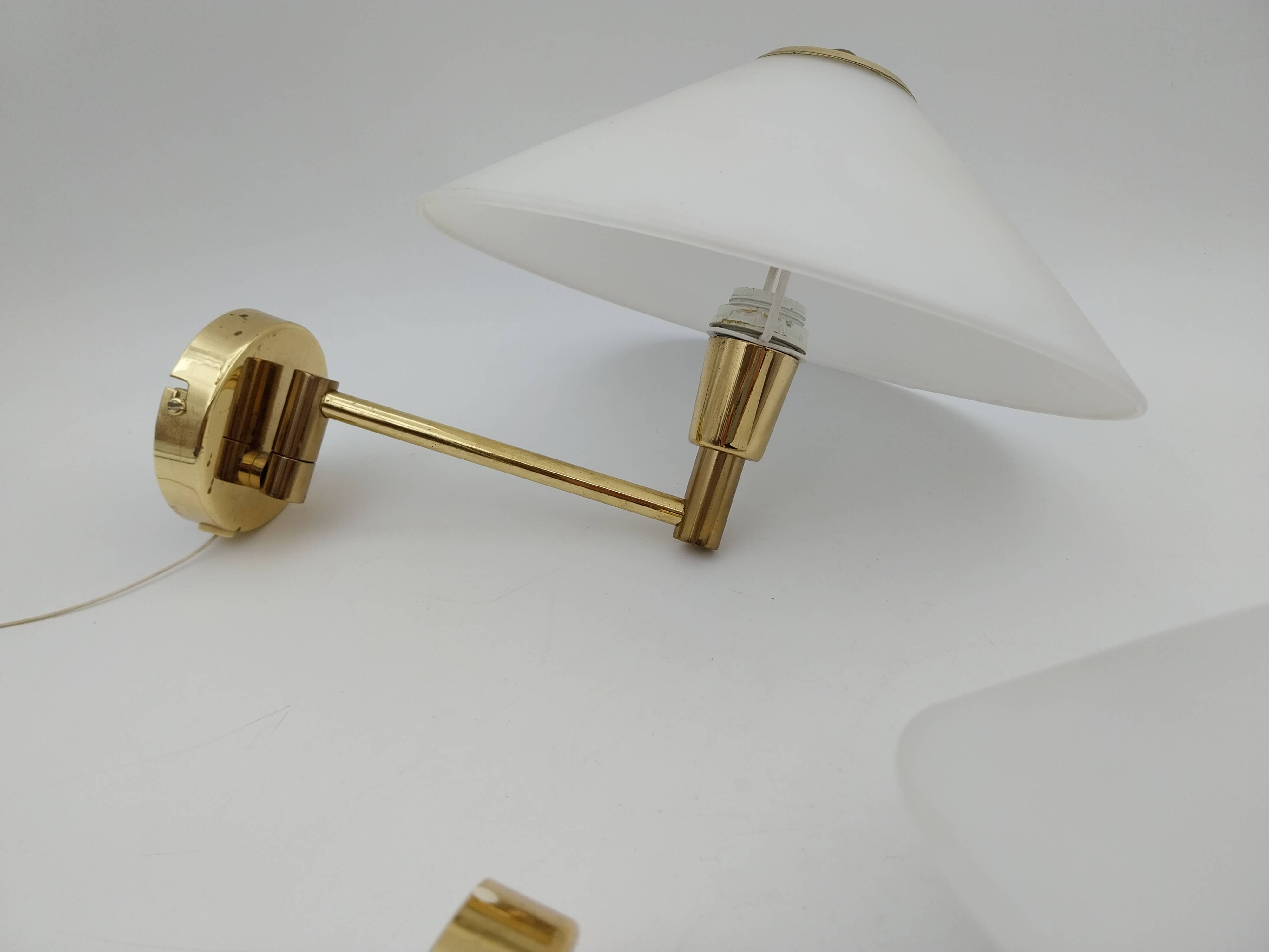 Pair of articulated arm wall lights in brass with opaline globe