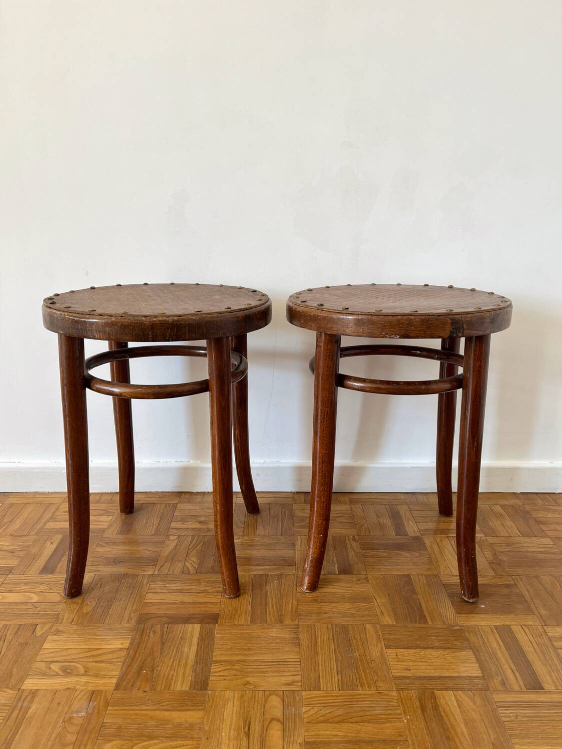 2 antique bistro stools with curved wood and caning effect.
