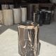 Black petrified wood side table with beige stripes and a semicircular shape.