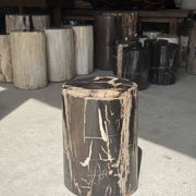 Black petrified wood side table with beige stripes and a semicircular shape.