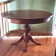Round solid walnut table with central leg from the 1950s with extensions.