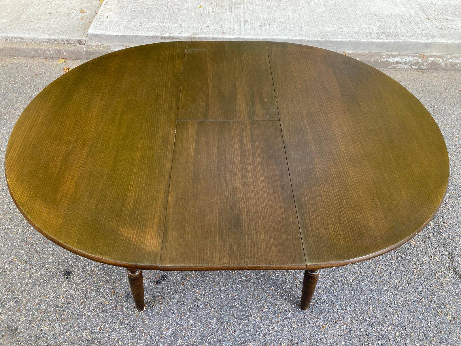Extendable round table in solid wood with a dark oak satin finish.