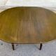 Extendable round table in solid wood with a dark oak satin finish.