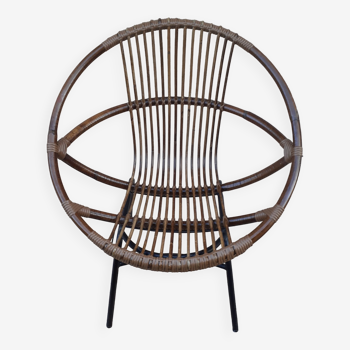 Shell-shaped armchair in rattan and metal legs. Caravan brand.