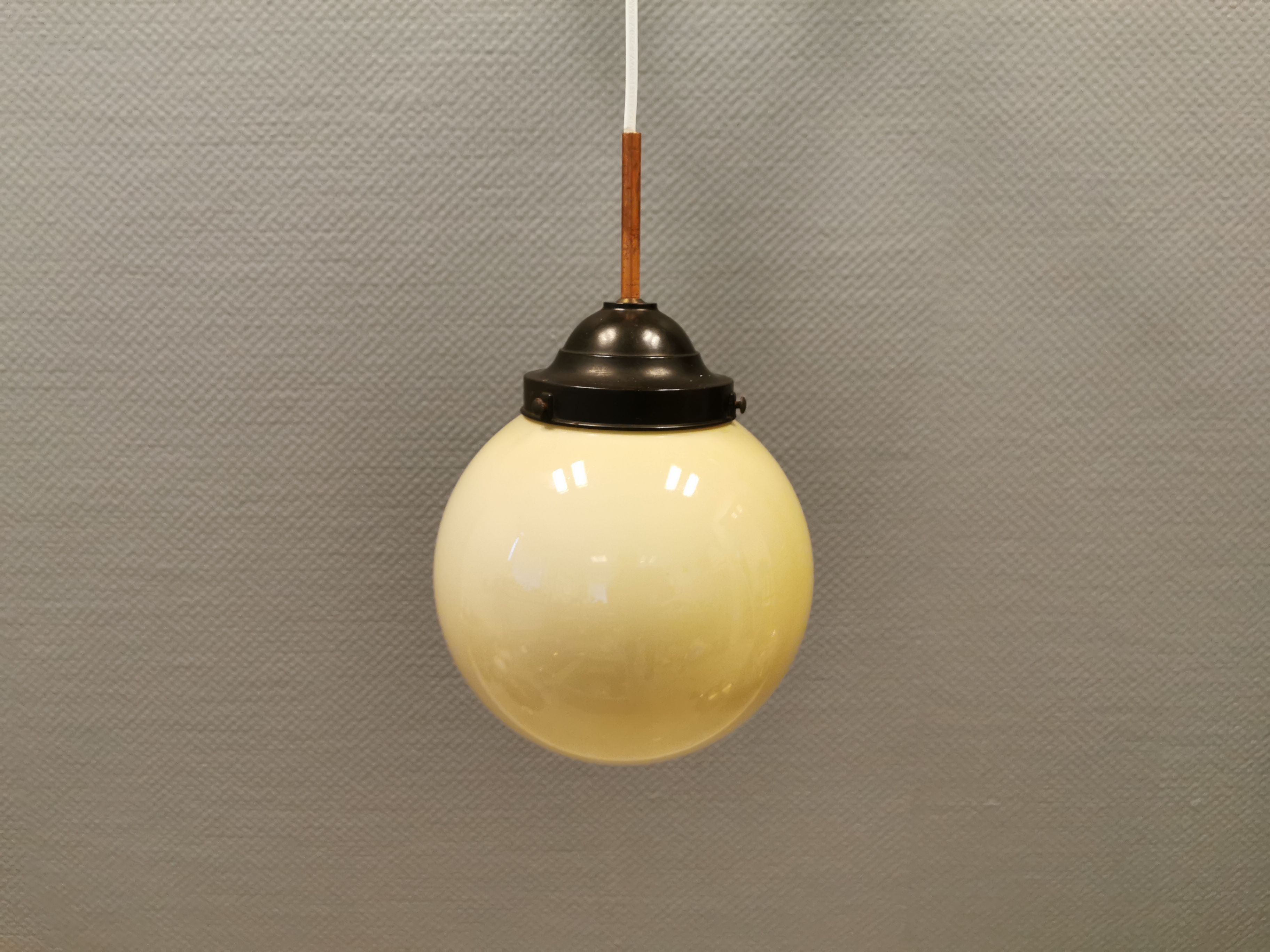 Small Art Deco hanging lamp in cream coloured glass and bakelite top.