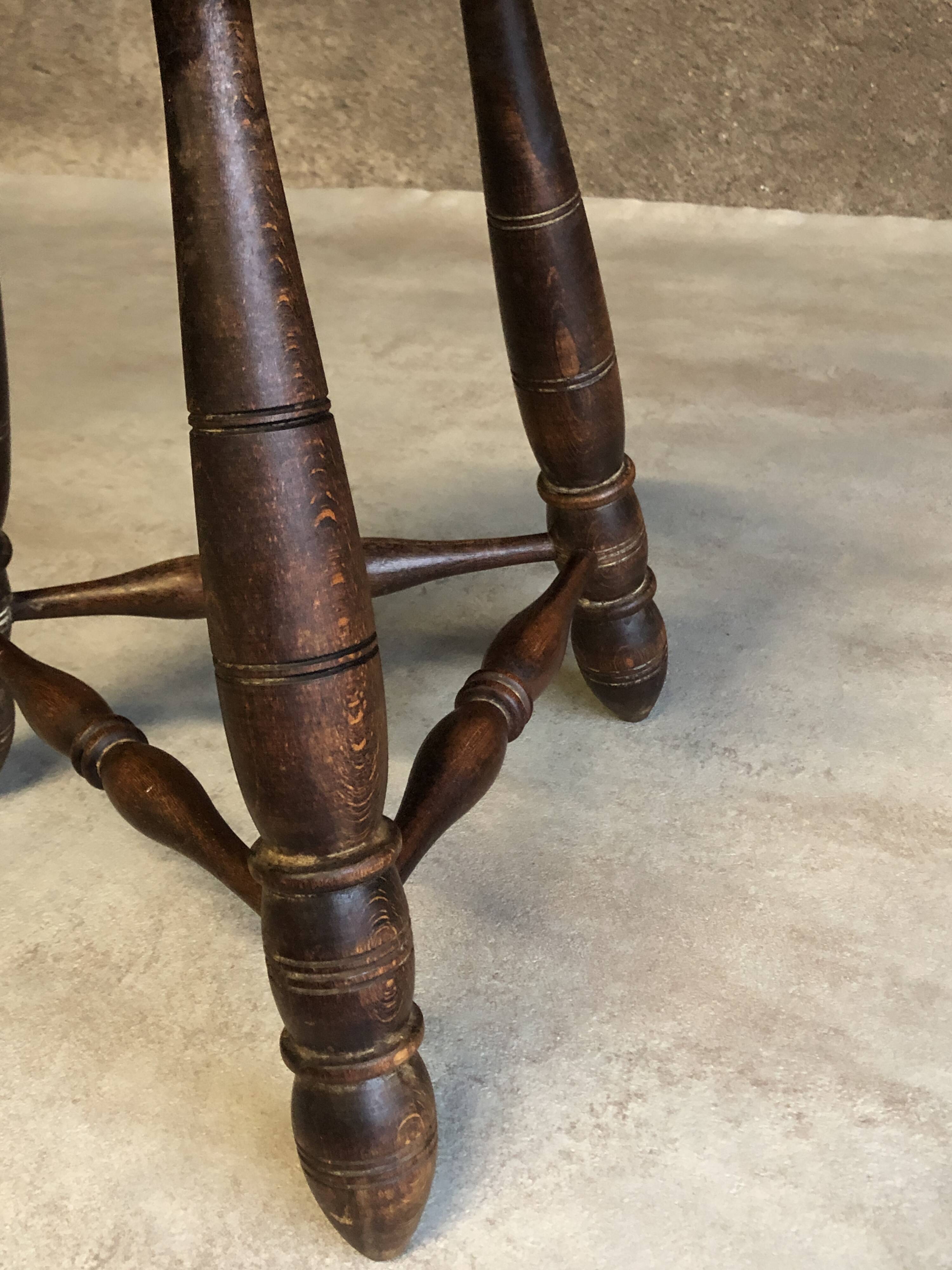 Round tripod stool in dark wood