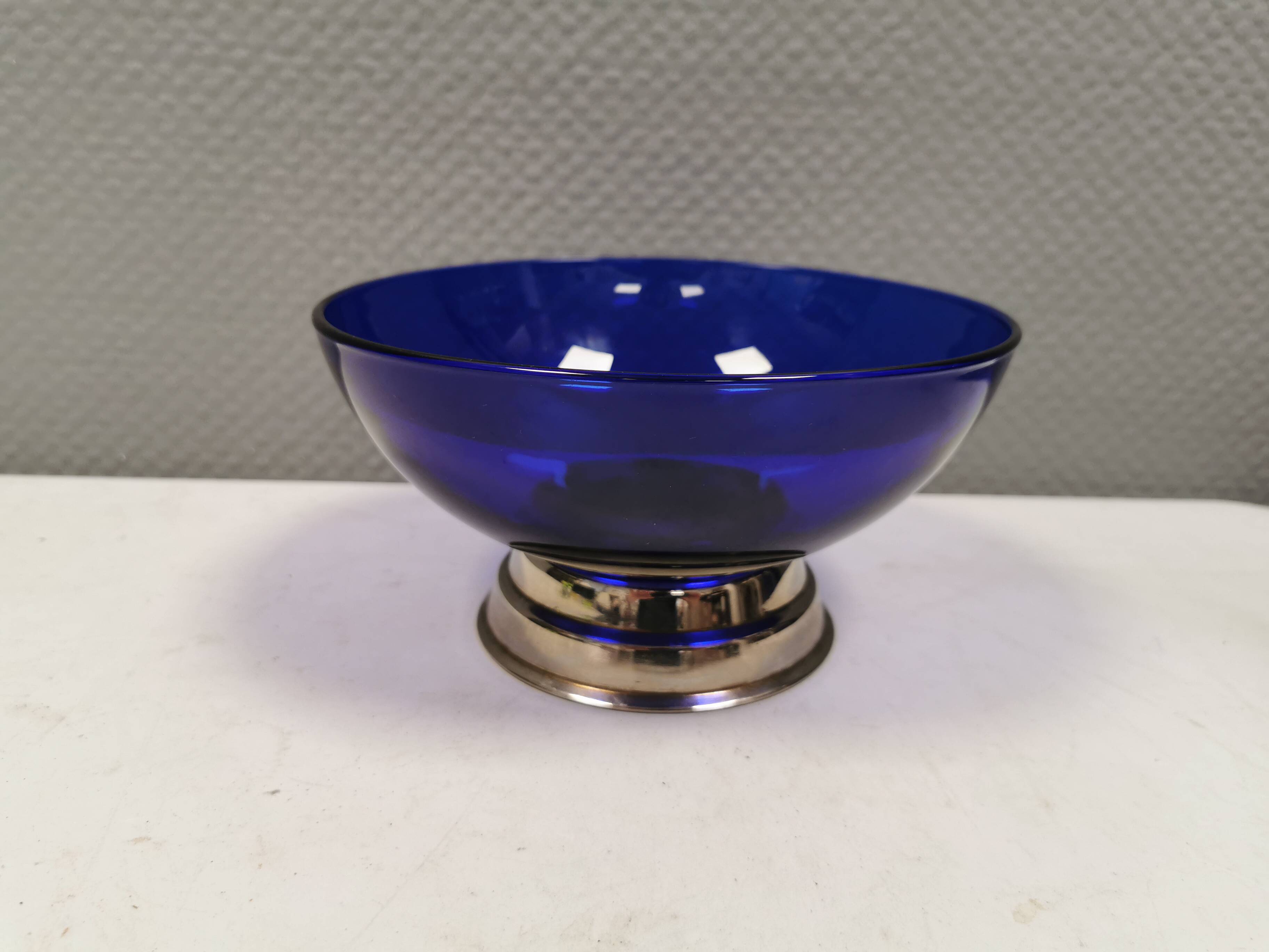 Beautiful blue glass bowl mounted on silver colored base (Original).