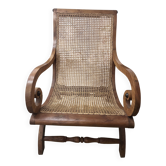 Colonial planter's armchair in solid teak, scroll armrests, caned seat.
