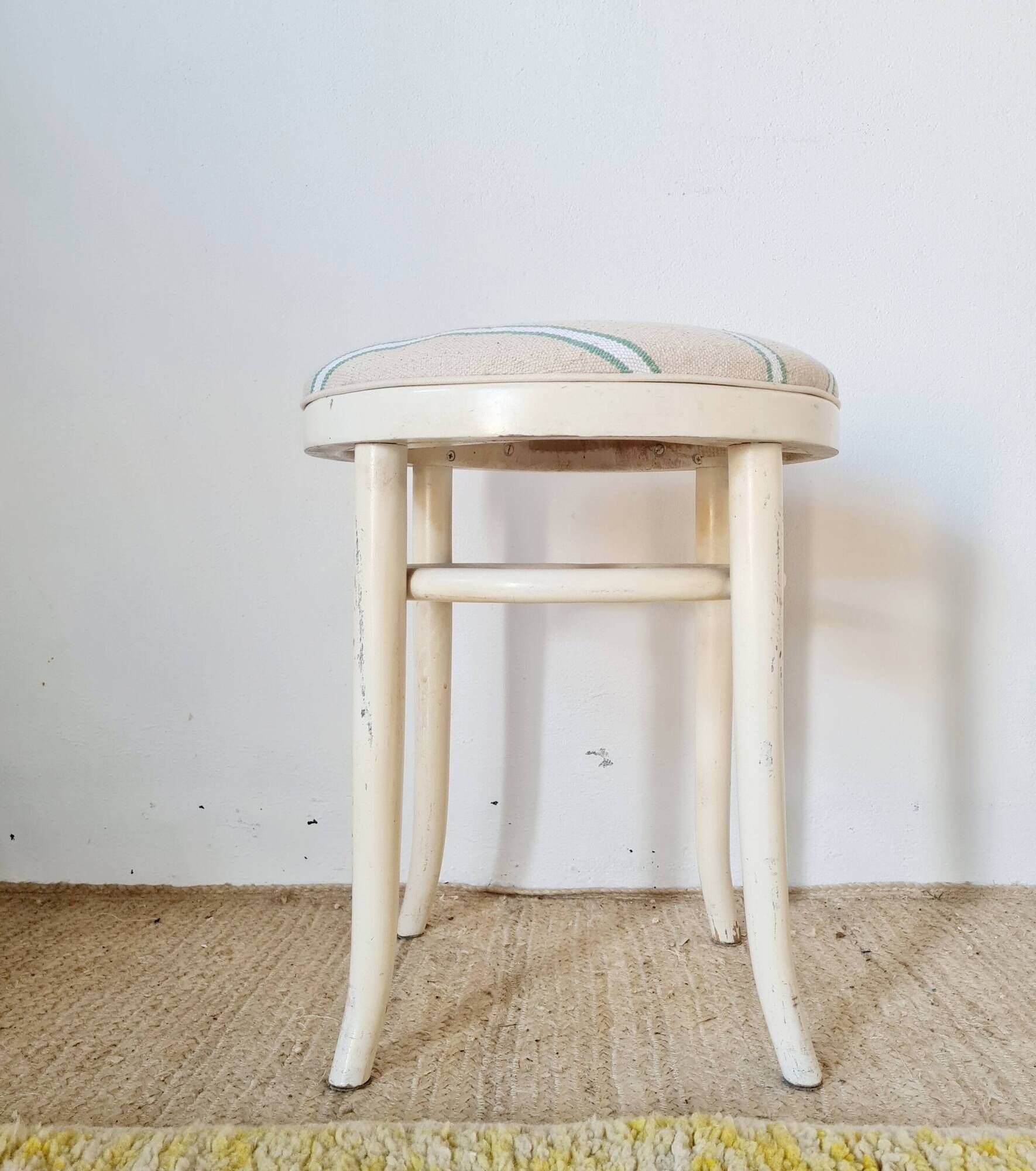 Vintage curved wooden stool in Baumann style, striped seat.