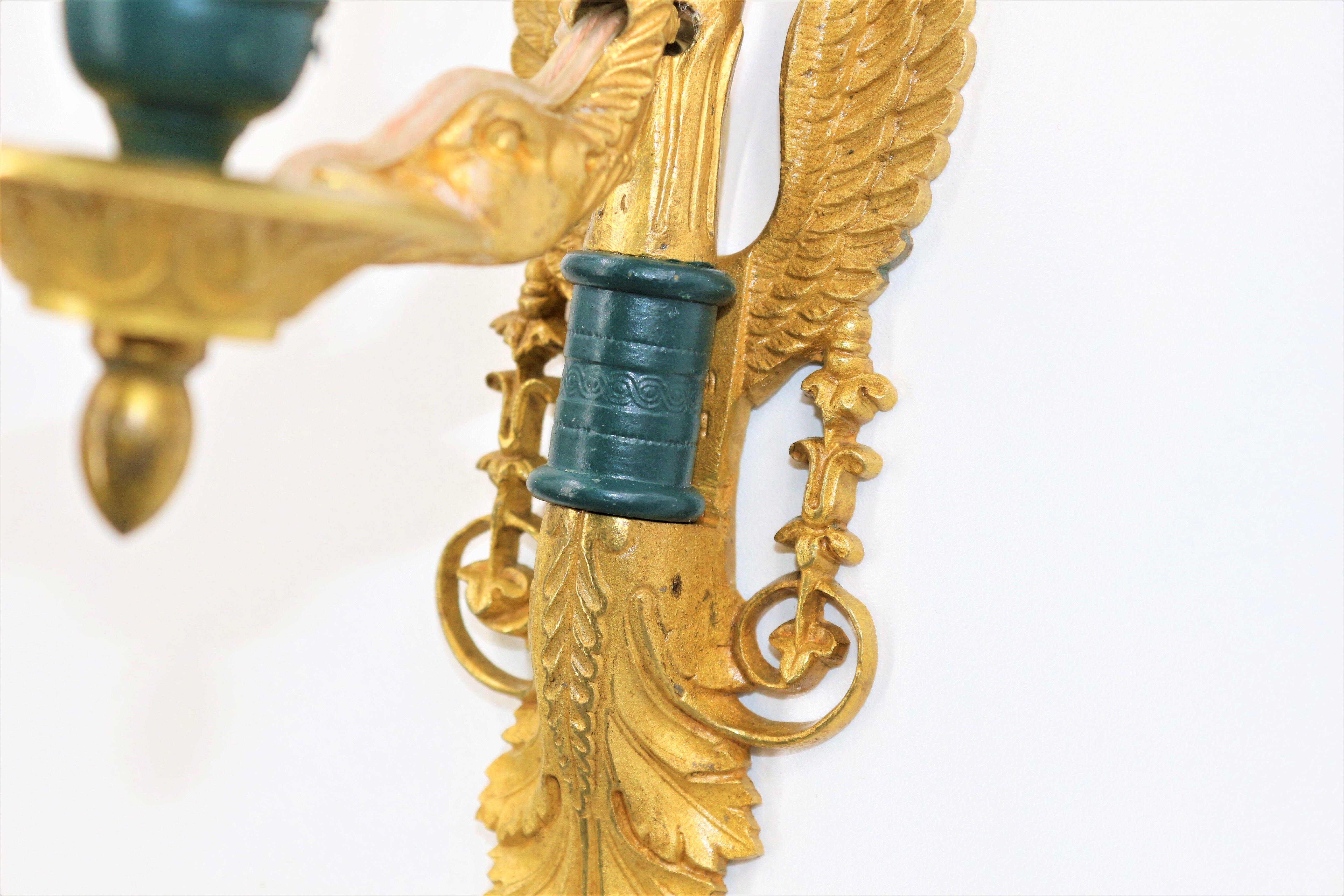 Pair of golden bronze wall lamps in triumphant empire swan style