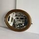 Antique oval mirror in gilded wood, bevelled mercury glass, 19th century.