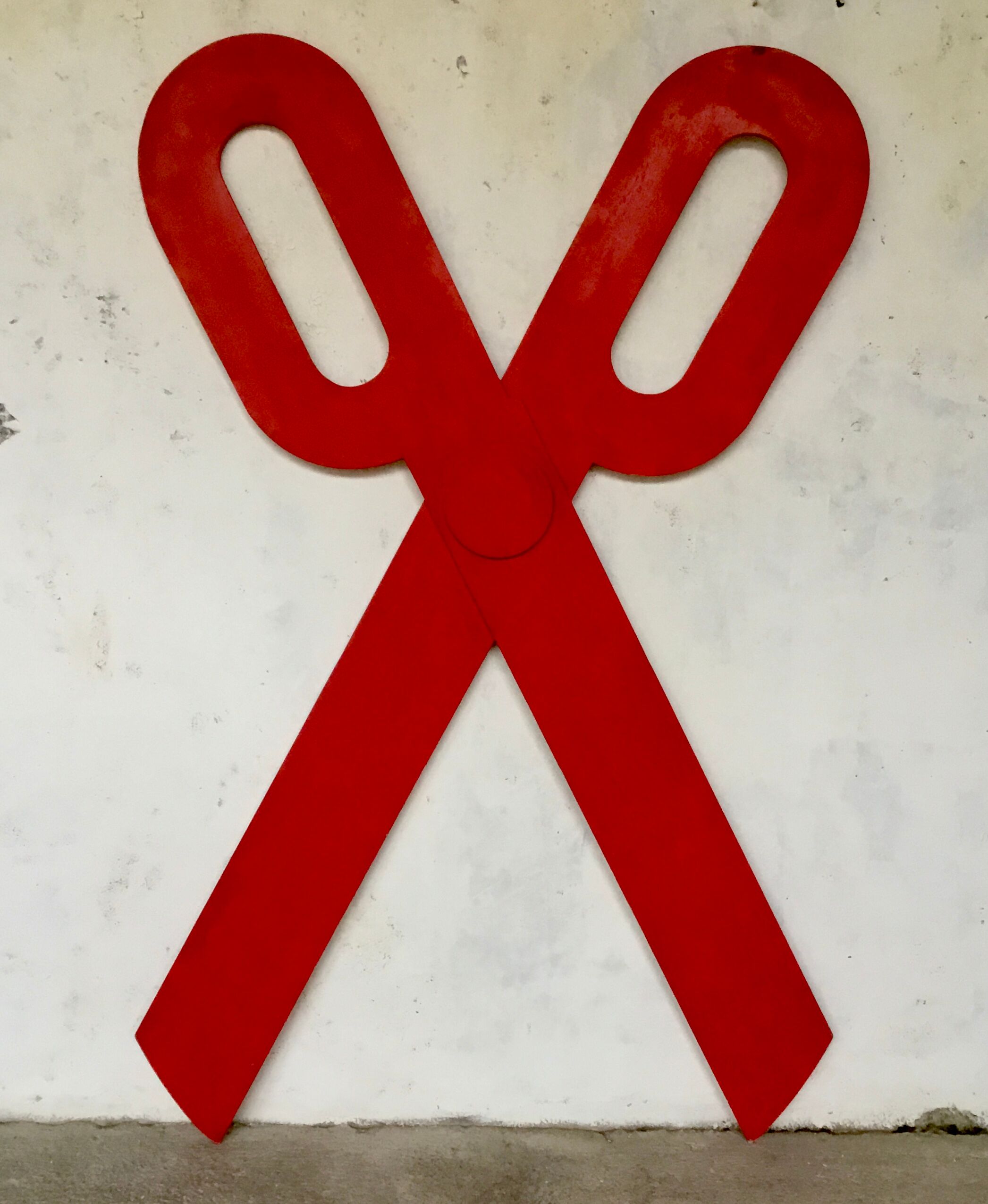Wooden sign in the shape of scissors