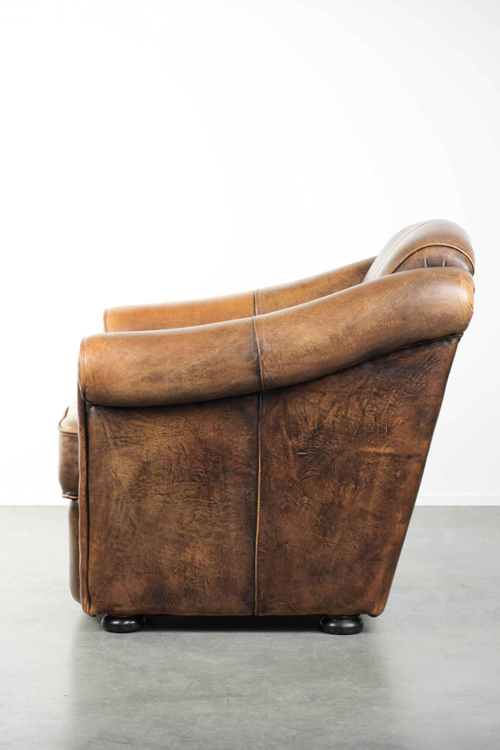 Fauteuil en peau de mouton magnifiquement conçu et confortable, avec un look intemporel et une finition de passepoil assortie.