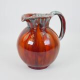 Large red and blue glazed ceramic pitcher signed Delène under the base