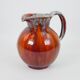 Large red and blue glazed ceramic pitcher signed Delène under the base