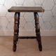 Tabouret marron en bois tourné.