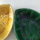 Two relief bowls with leaf designs, radishes, and tomatoes.