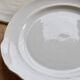 Vintage round white porcelain serving dish with handles.