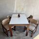 Mid-century white laminate dining table with dark wood base and 4 beige upholstered chairs