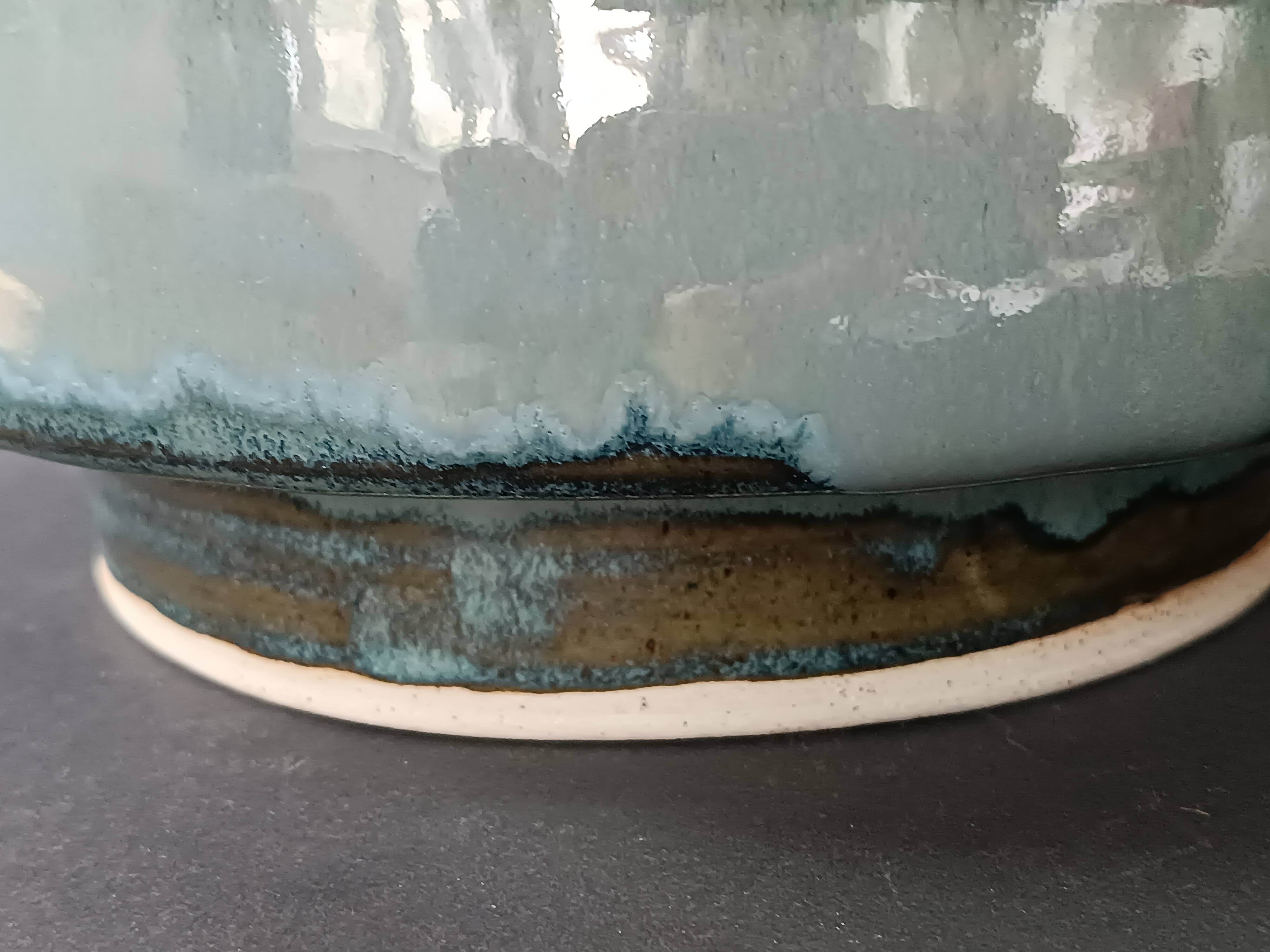 Glazed stoneware jardinière in almond green, semi-circular, signed.