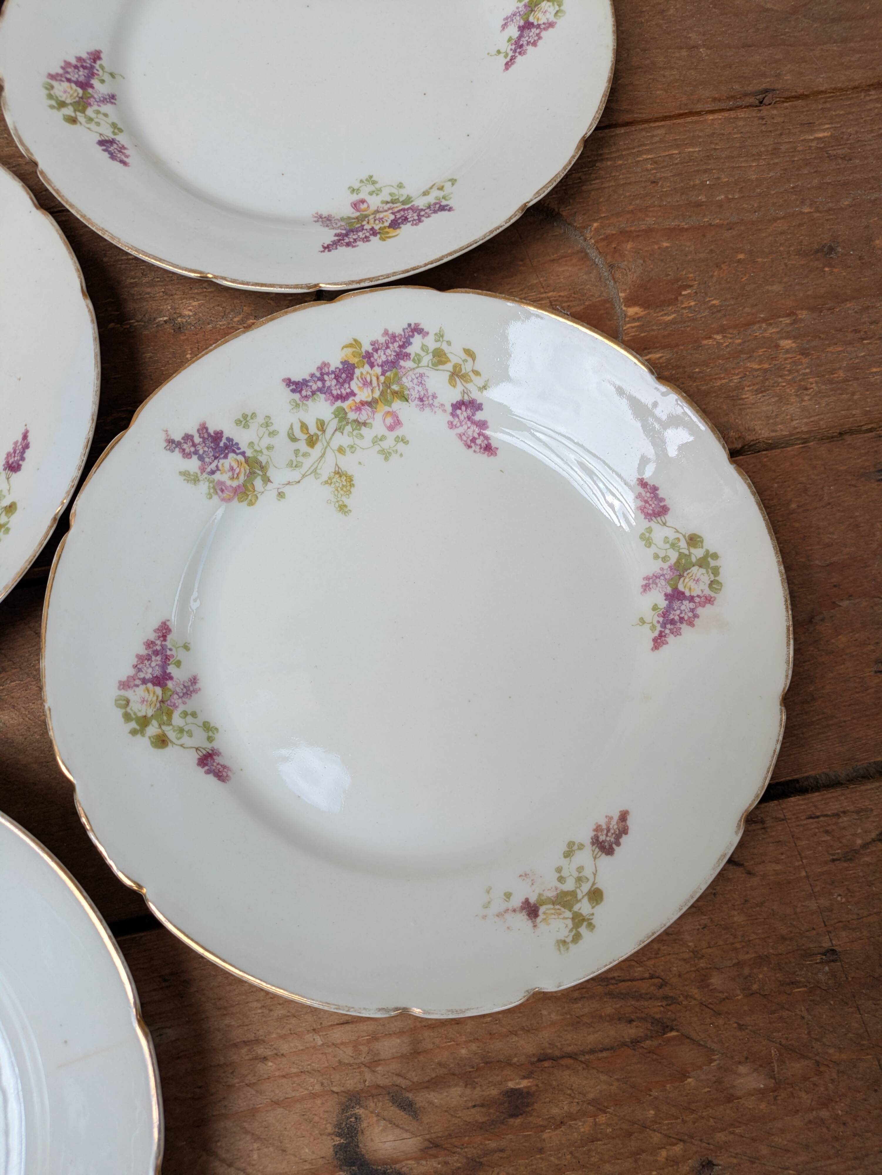 7 dessert plates in porcelain with a violet lilac design and a gold rim.