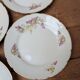 7 dessert plates in porcelain with a violet lilac design and a gold rim.