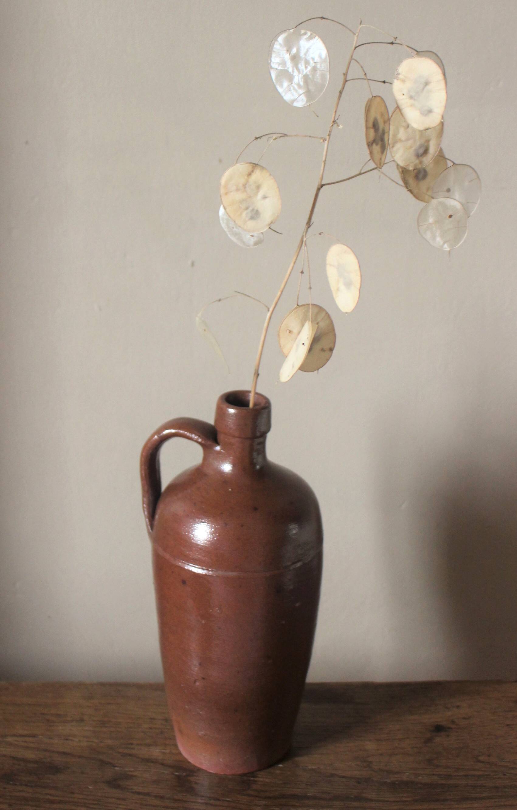 Vintage stoneware liqueur bottle with handle and spout.