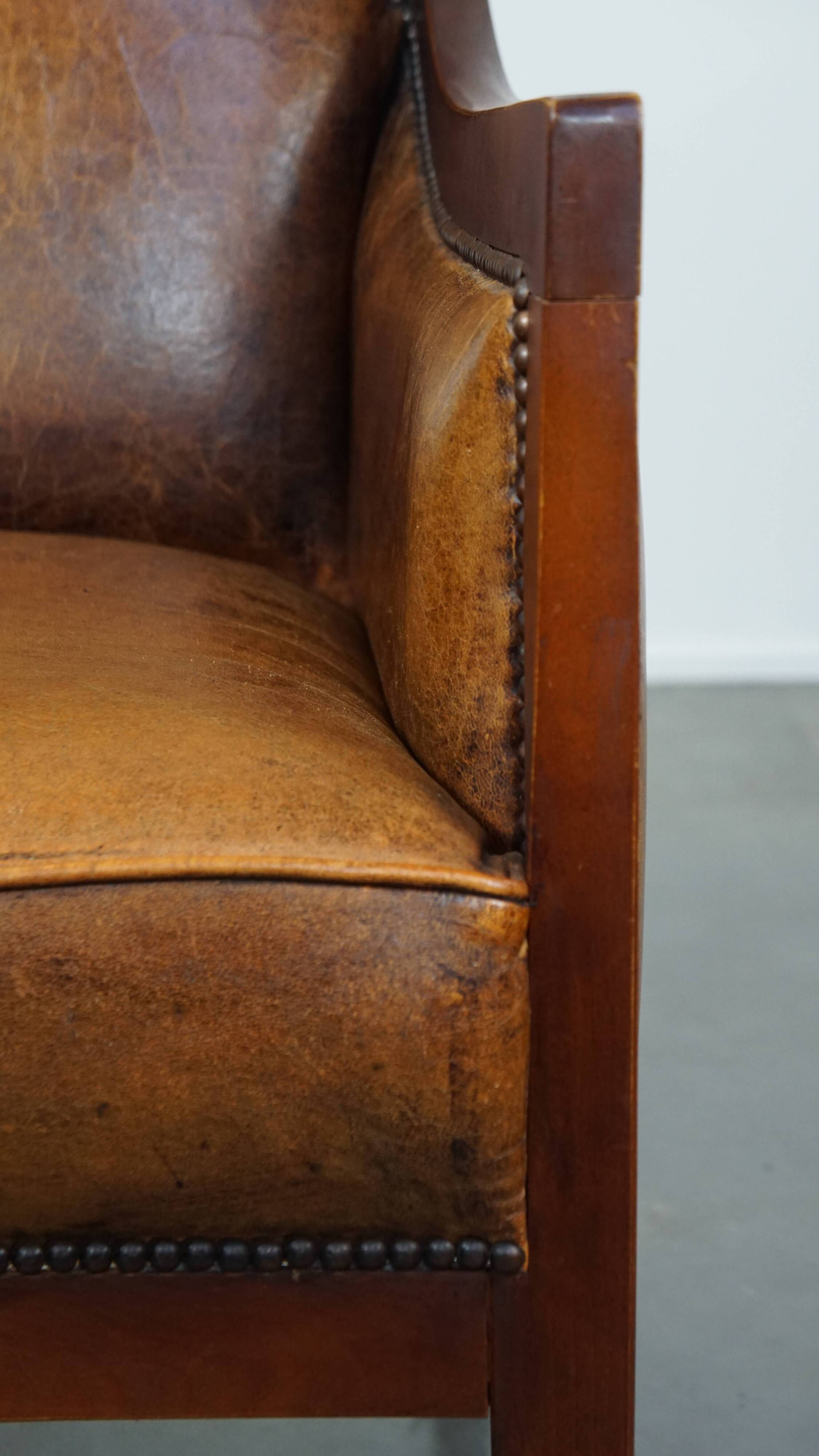 Sheepskin and wooden vintage Art Deco design armchair in a cognac color