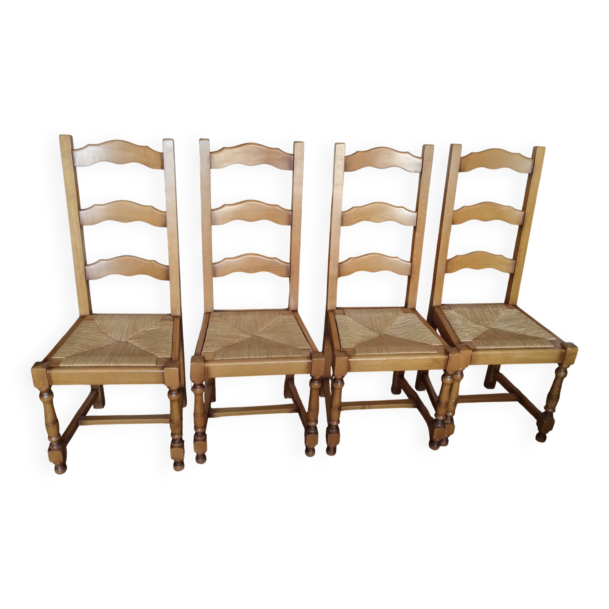 4 straw-seated solid wood chairs with high backs in rustic style.