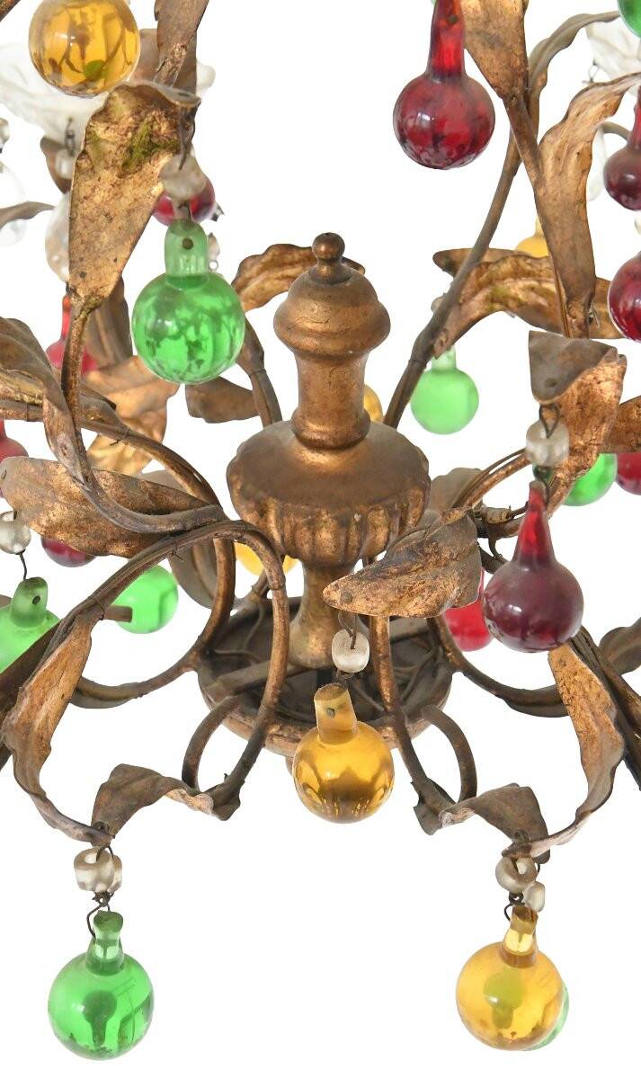 Lustrous chandelier with two wall lights decorated with foliage and pendants.