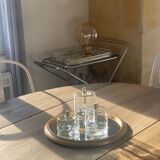 Oval wooden table with drop-leaf edges.