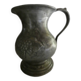 pewter pitcher with handle and bunch of grapes on the pot