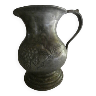 pewter pitcher with handle and bunch of grapes on the pot