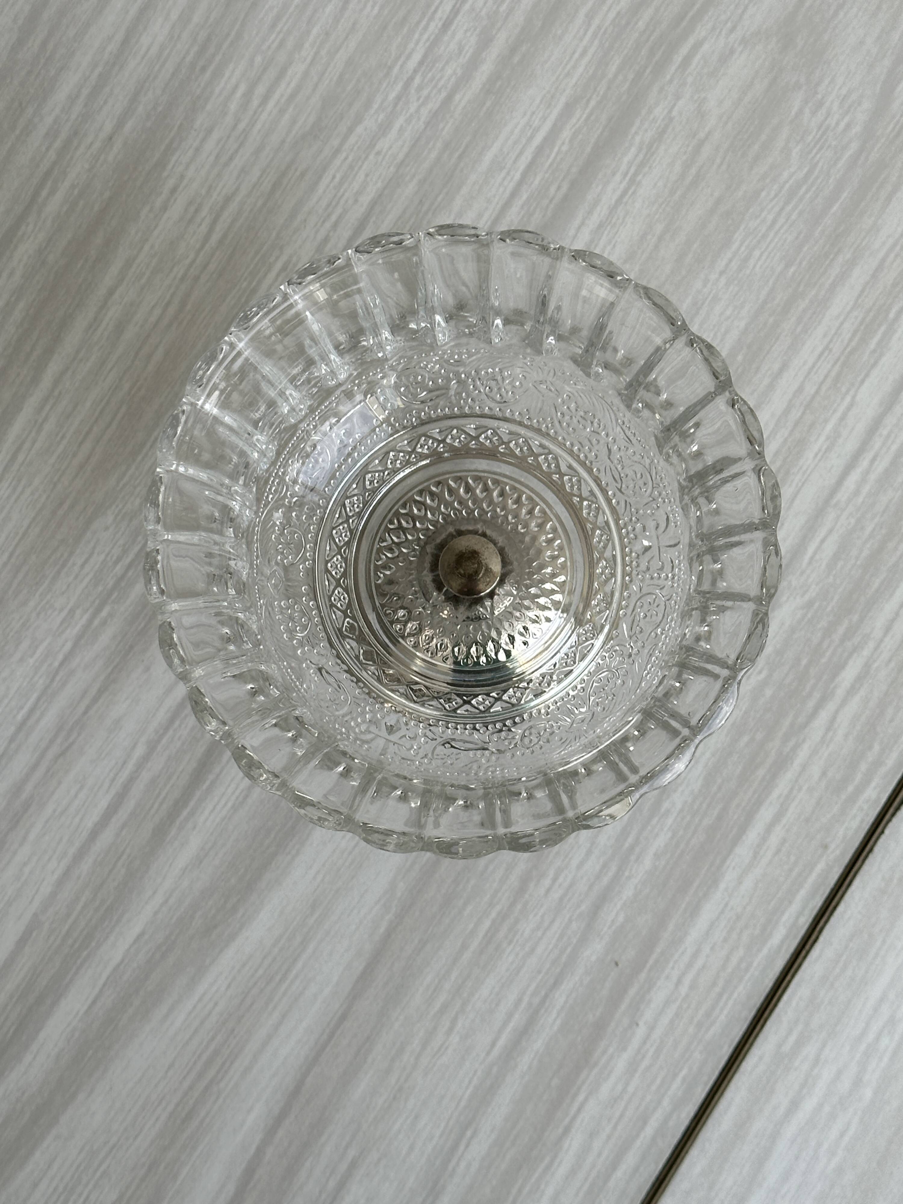 Thick glass bowl on a metal stand.