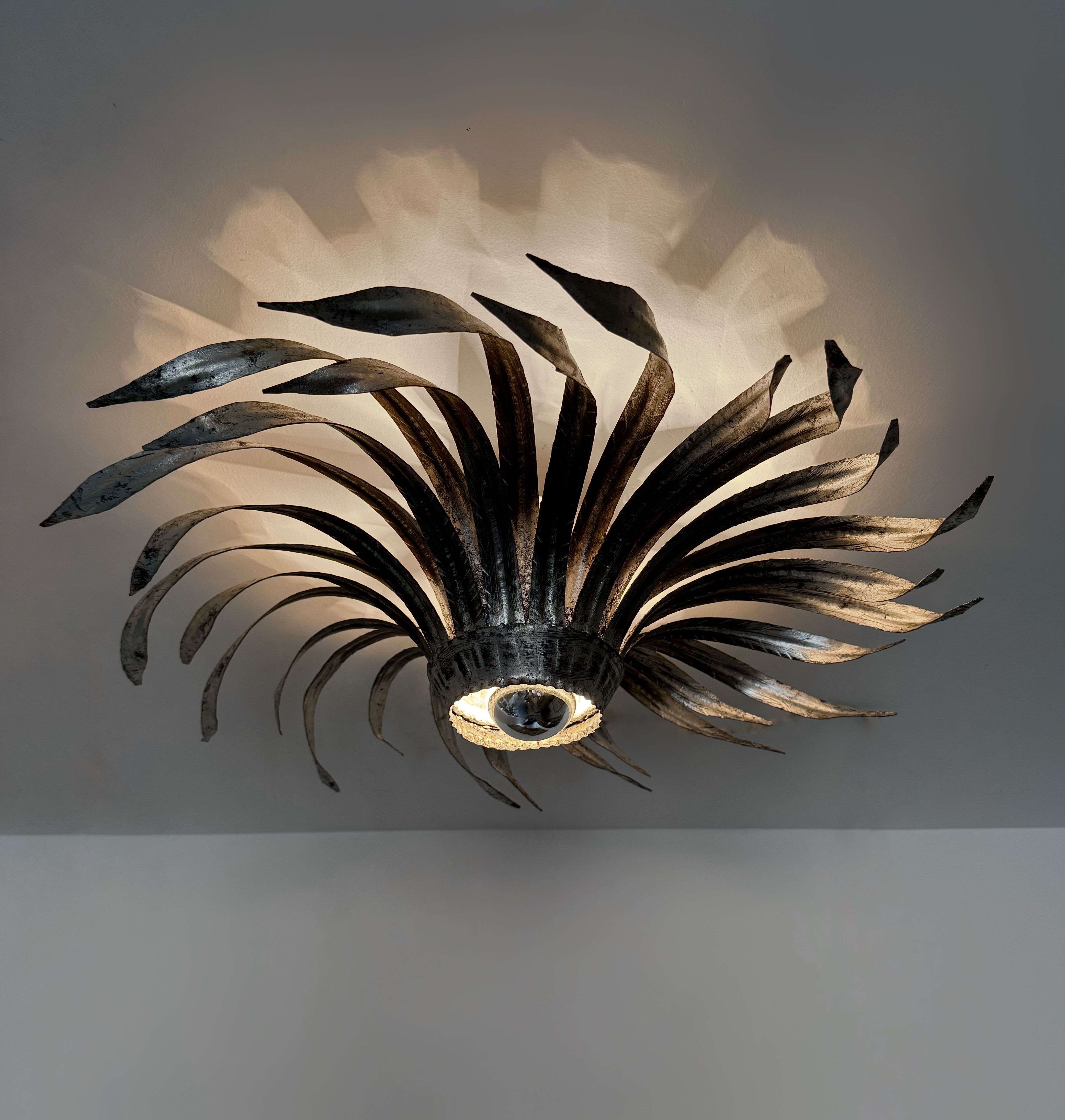 Silver wrought iron sunburst wall light from the 1960s.