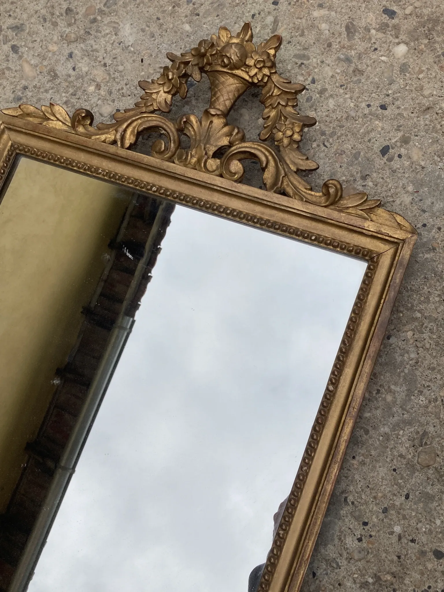 Antique mirror in wood and gilded stucco with a pediment - in the style of the 18th century.