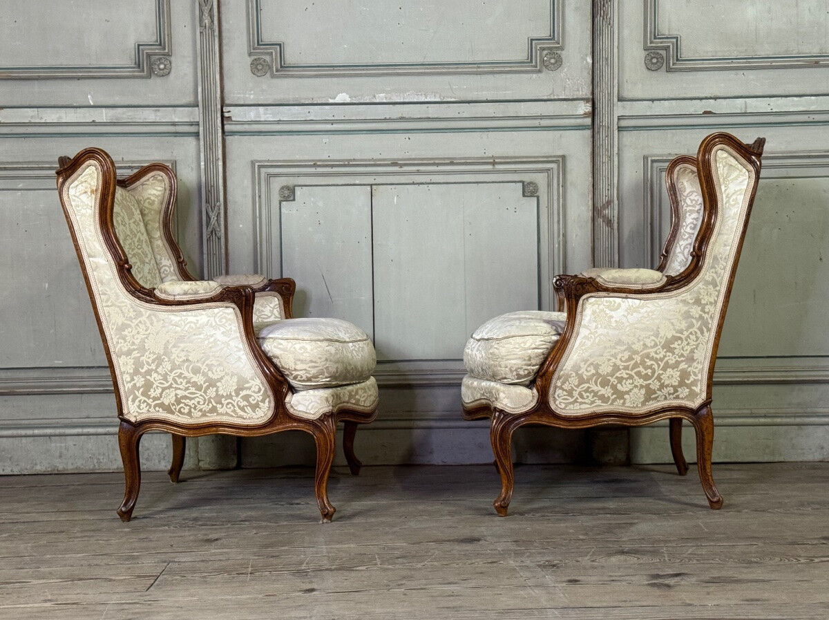 Pair of small Louis XV style wing chairs in carved walnut, Bosson stamp