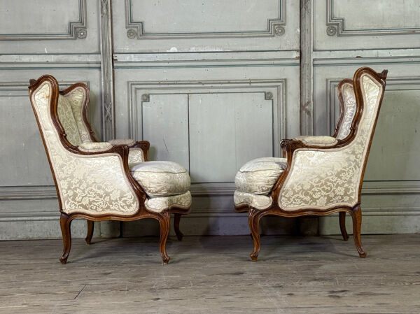Paire de petites bergères à oreilles de style Louis XV en noyer sculpté, estampille de Bosson