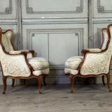 Pair of small Louis XV style wing chairs in carved walnut, Bosson stamp