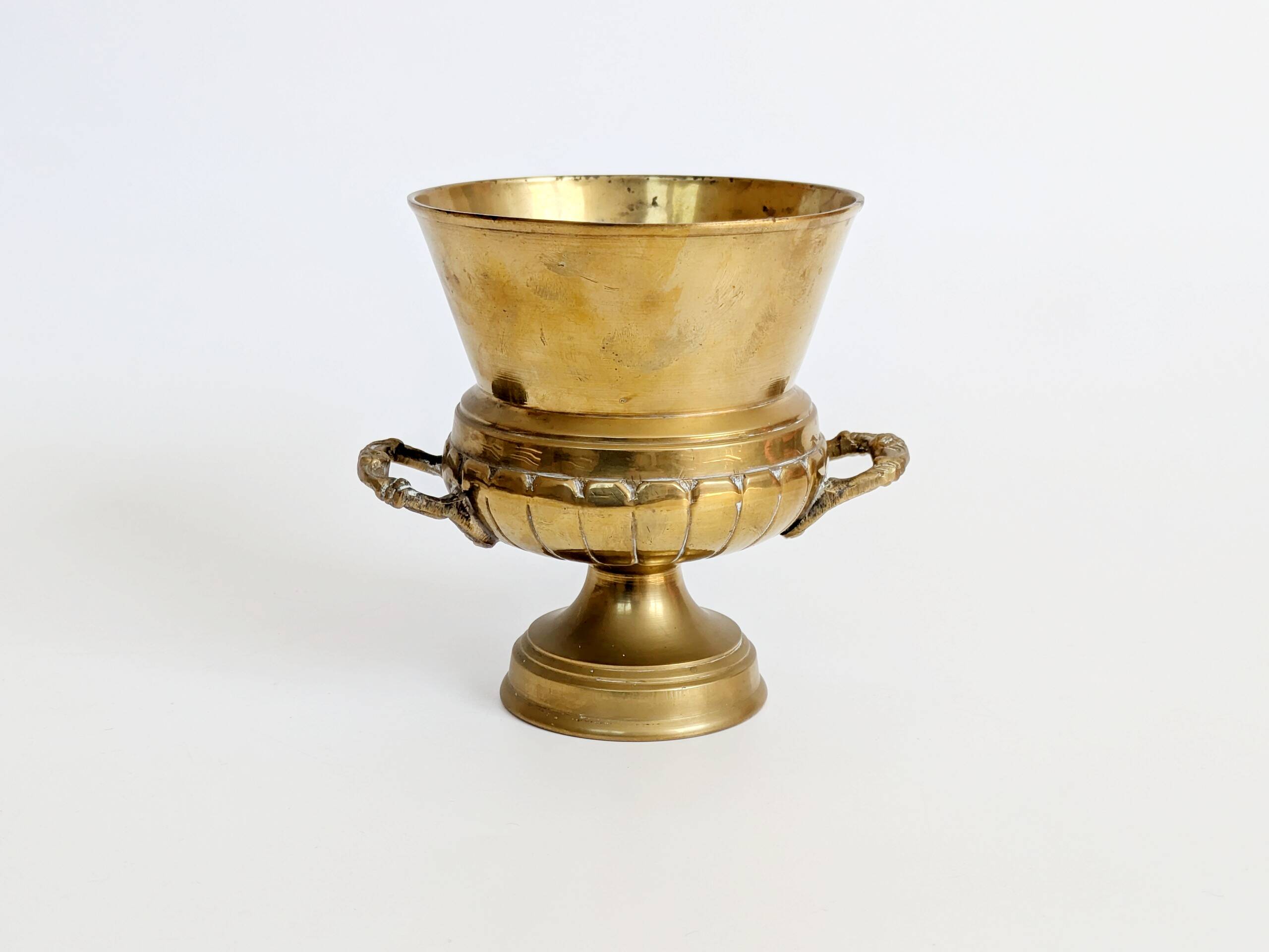 Vintage brass cache-pot on a stand with handles, classic decor.