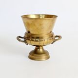 Vintage brass cache-pot on a stand with handles, classic decor.