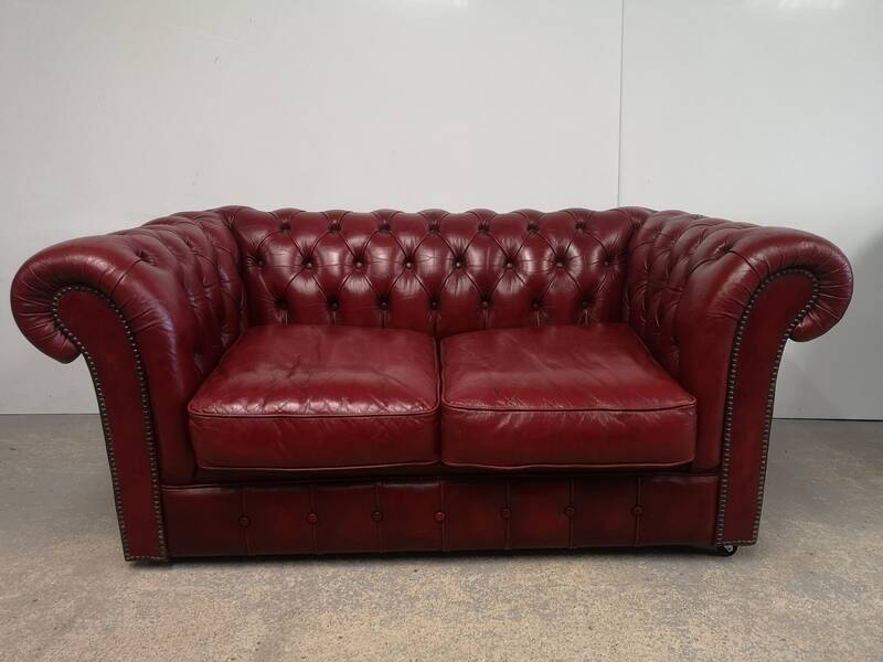 Red two-seater chesterfield sofa