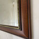 Vintage bevelled wall mirror in stained wood and brass